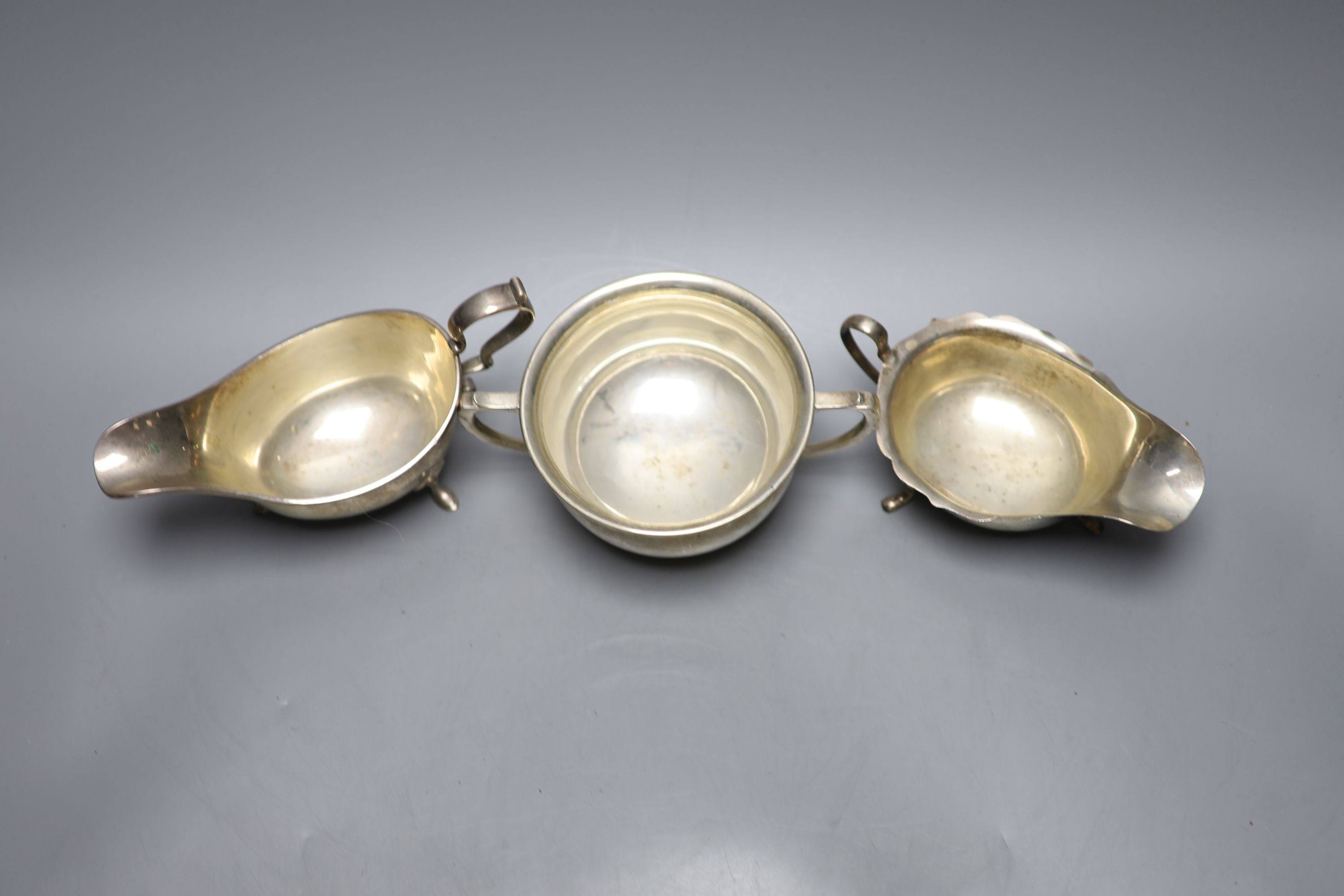 Two George V silver sauceboats and a similar silver two handled sugar bowl, with engraved inscription, 15.5oz.